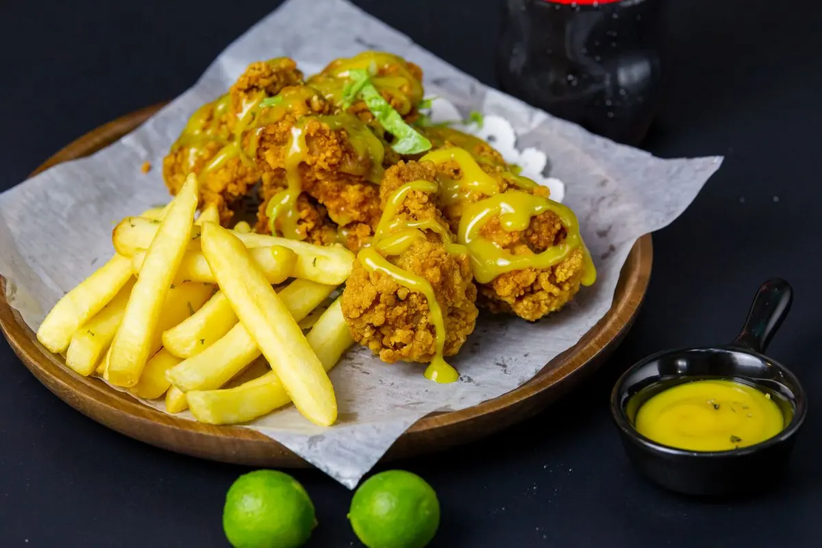 Crispy fried chicken and fries served on a wooden platter