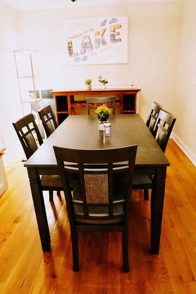 Dining room with a dark wood table for six and a 'Lake' sign on the wall