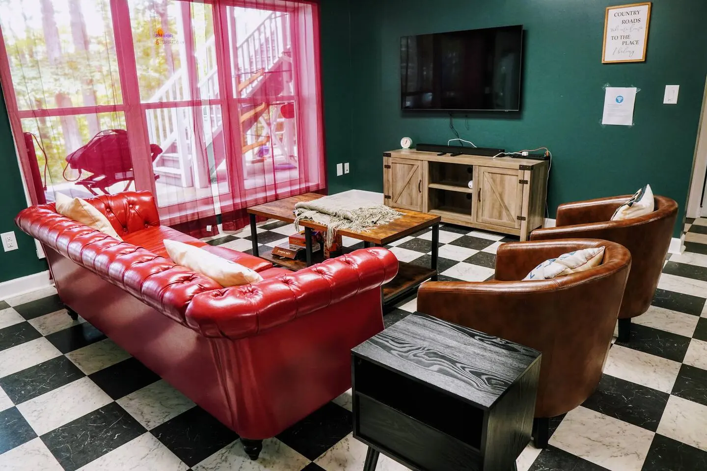 Basement lounge with red leather sofas facing a TV