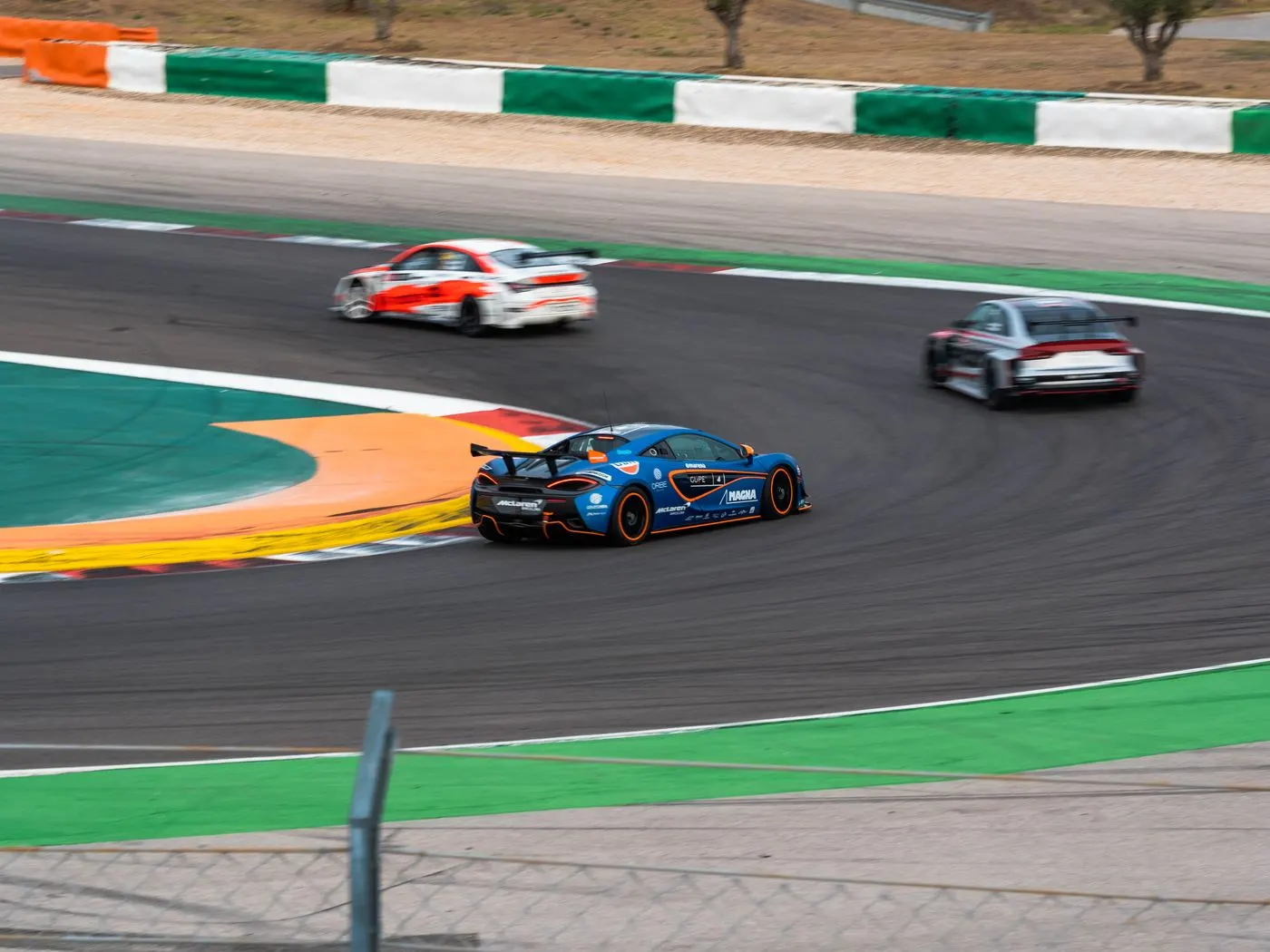 Sports cars cornering on a road-racing circuit
